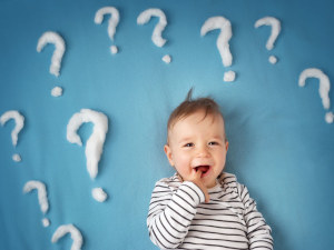 Kleinkind mit Fragezeichen – Symbol für häufige Fragen von Eltern zum Babyschlaf und Kinderschlaf